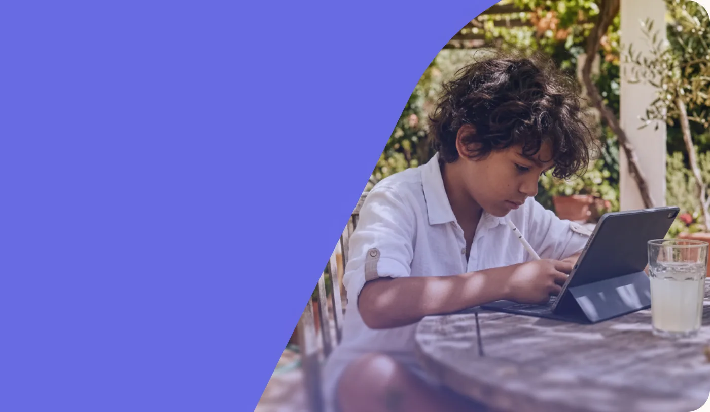 A child working on a tablet at a garden table